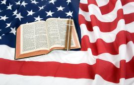 A Bible and the Christian cross on top of an American Flag.