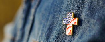 Christian cross pin on denim background