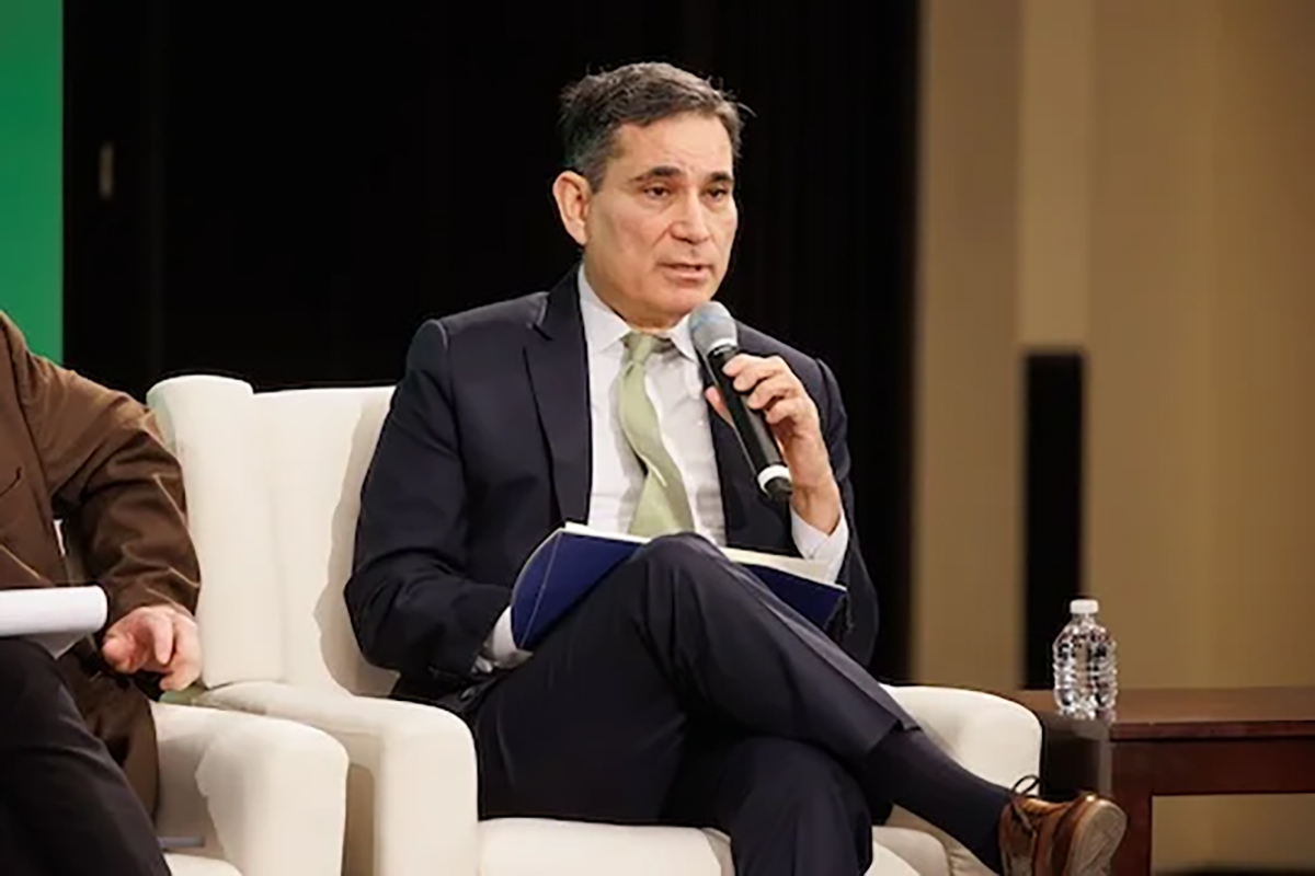 Tony Payan sits in armchair speaking to audience
