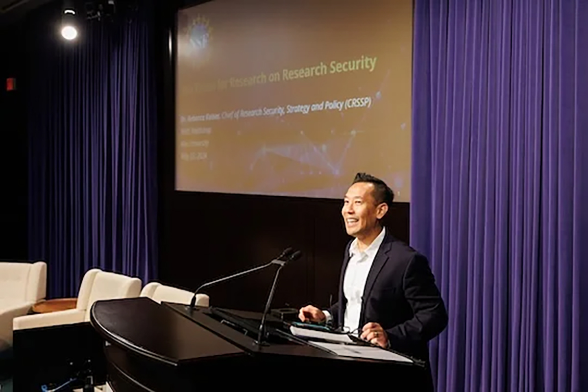 Tam Dao delivering remarks from podium.