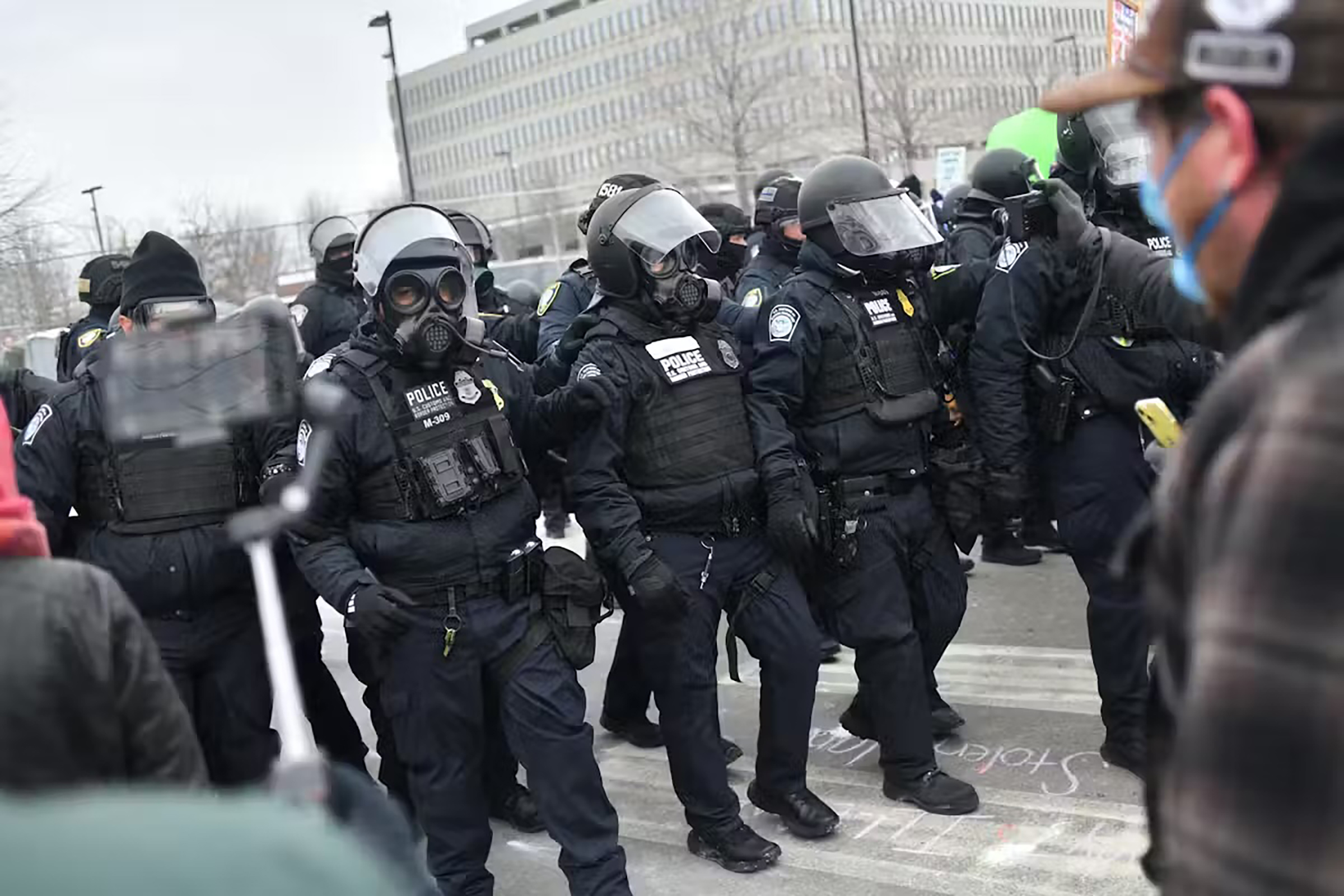 Federal law enforcement agents confront anti-ICE protesters outside the Bishop Whipple Federal Building in Minneapolis on Jan. 15, 2026.