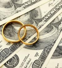  Golden wedding rings on one hundred dollars bill background 