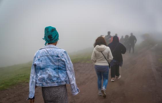 Refugees walk on dirt path