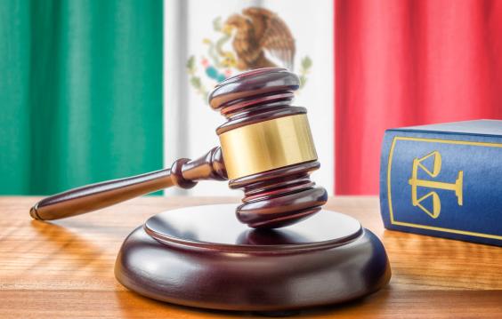 A gavel rests in front of the Mexican flag.