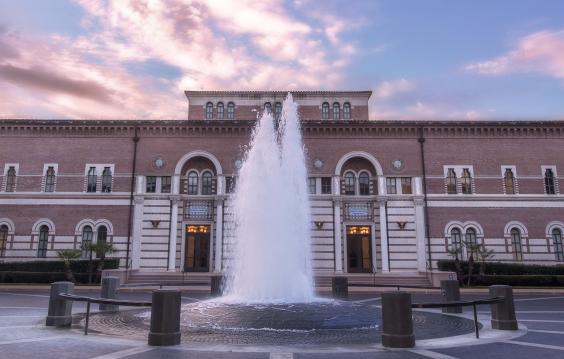 The front of Baker Hall, from across the plaza, with fountain in foreground