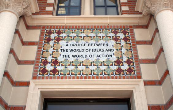 Tile mosaic over an entrance to Baker Hall that reads "A Bridge Between the World of Ideas and the World of Action"