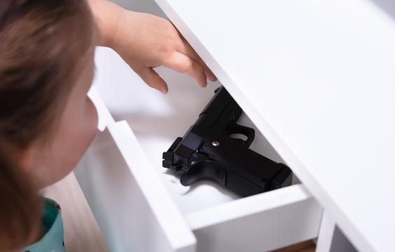 Small child reaches into drawer with firearm