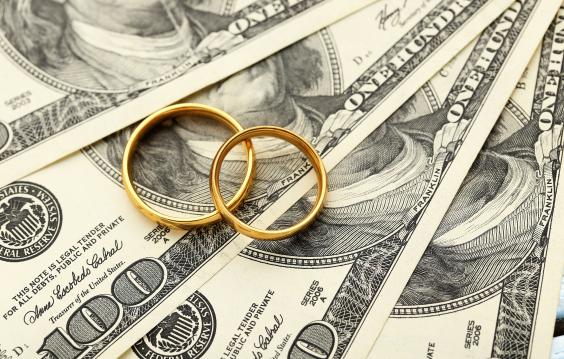  Golden wedding rings on one hundred dollars bill background 