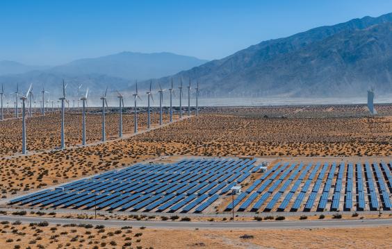 solar panels and wind turbines in desert landscape
