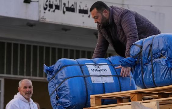 A man unloads humanitarian aid supplied by the U.N. refugee agency UNHCR at a school in Beirut used as a shelter for people displaced by Israeli airstrikes.