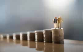 Two old people standing on a stack of coins.