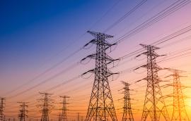 Transmission towers against a sunset.
