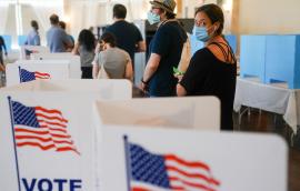 Woman with mask waiting in line to vote in a U.S. election.