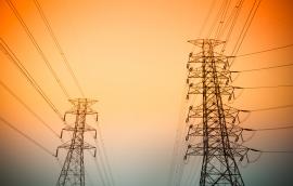 Transmission towers against a sunset.
