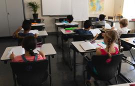 Children sit at desks in school