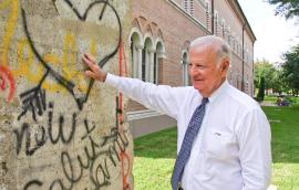 Secretary James A. Baker, III, stands with a portion of the Berlin Wall, outside of Baker Hall