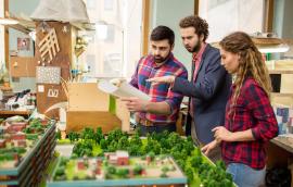 Landscape designers having discussion about city layout model 