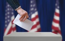Voter holds envelope in hand above vote ballot