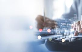 financial information superimposed over hands above keyboard