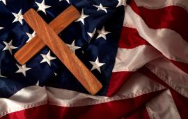  a wooden cross on the american flag