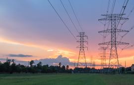 Group silhouette of transmission towers at dusk