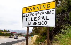 Road sign near U.S.-Mexico border that says "Warning: Weapons/ammo illegal in Mexico"