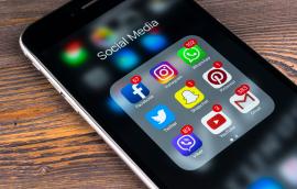Apple iPhone 7 on wooden table with icons of social media