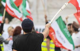 Man holding Iranian flag at women’s rights protest