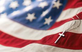 Christian cross necklace on American flag.