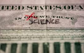 Word God crossed out and replaced by science on a US dollar bill. 