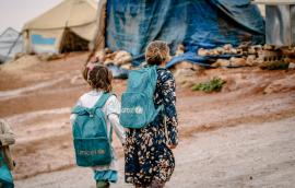 Refugee girls wearing UNICEF backpacks