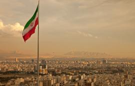 Iran Flag in the Wind Above Skyline of Tehran 