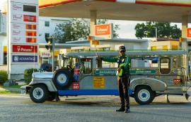 Traffic officer manages jeepney at petrol station