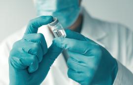  Medical professional holding booster shot Covid-19 vaccine bottle vial 
