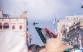 Foto de la bandera de México entre la gente en el centro histórico de Morelia.