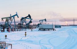 Oil Field. Winter industrial landscape with an oil pump and torch in the background. 