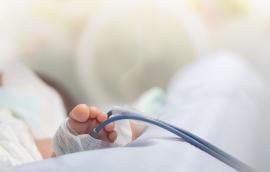 Infant or newborn baby feet with pulse oximeter for determine oxygen saturation in baby's blood, in incubator at intensive room care in the hospital after delivery.