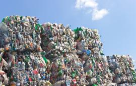 Stack of plastic bottles for recycling against blue sky