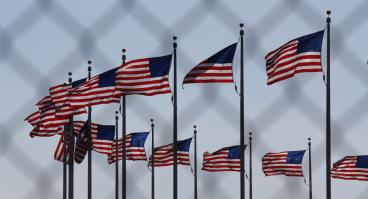 U.S. flags behind a chain-link fence