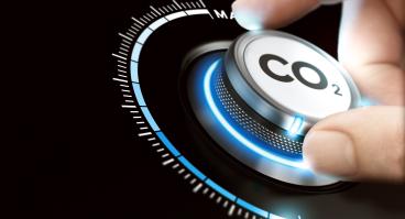A person's hand on dial with carbon dioxide (CO2) written on it.