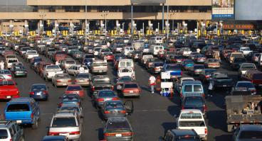 Multiple rows of cars lined up at the US-Mexico border. 