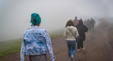Refugees walk on dirt path