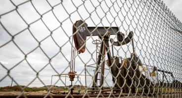 An oil pump behind a fence.
