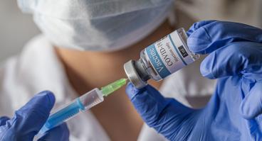 A medical worker fills a syringe with the COVID-19 vaccine 