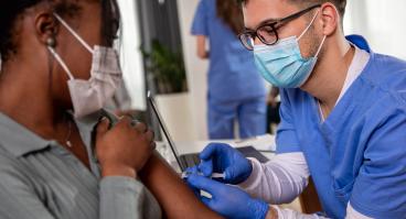 Nurse administering covid vaccine to a woman