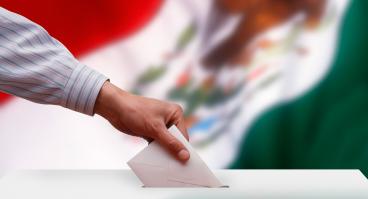 Ballot box in front of the Mexican flag