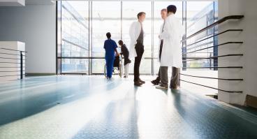 Doctors converse in a corridor.