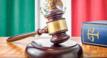 A gavel rests in front of the Mexican flag.