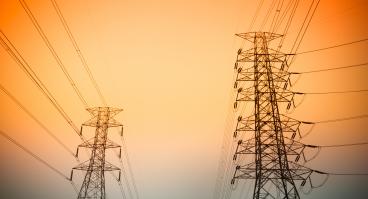 Transmission towers against a sunset.