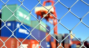 Trade containers behind a fence.
